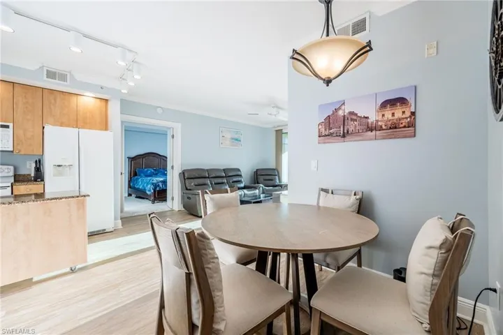 Dining room featuring ornamental molding, light wood-style flooring, rail lighting, and a ceiling fan