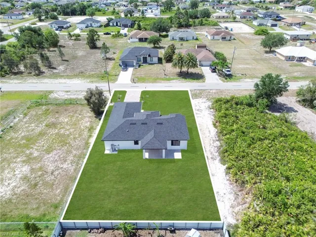 Newly constructed single-story residence featuring a dark shingle roof and a light-colored exterior