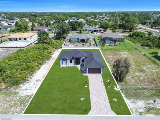 Contemporary single-story residence featuring a dark shingle roof, light-toned exterior siding, and a paver driveway