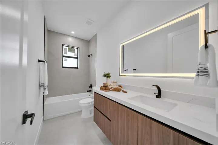 Bathroom featuring a modern vanity with wood-finish cabinetry and a white countertop with integrated sink