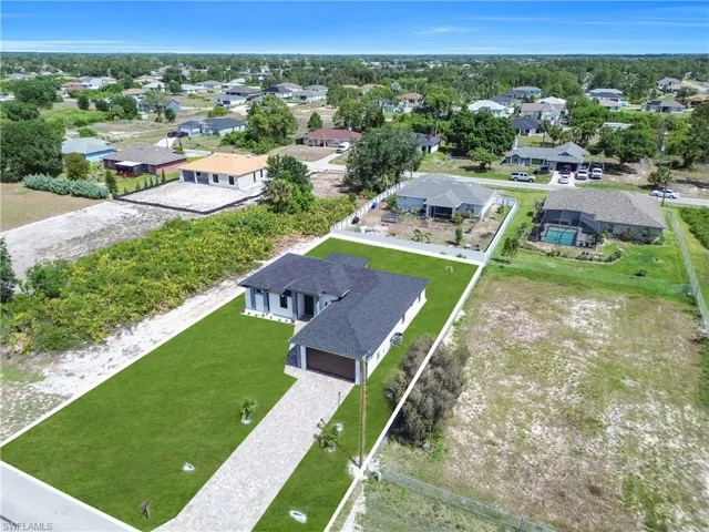 Newly constructed residence featuring a dark shingle roof and a two-car garage
