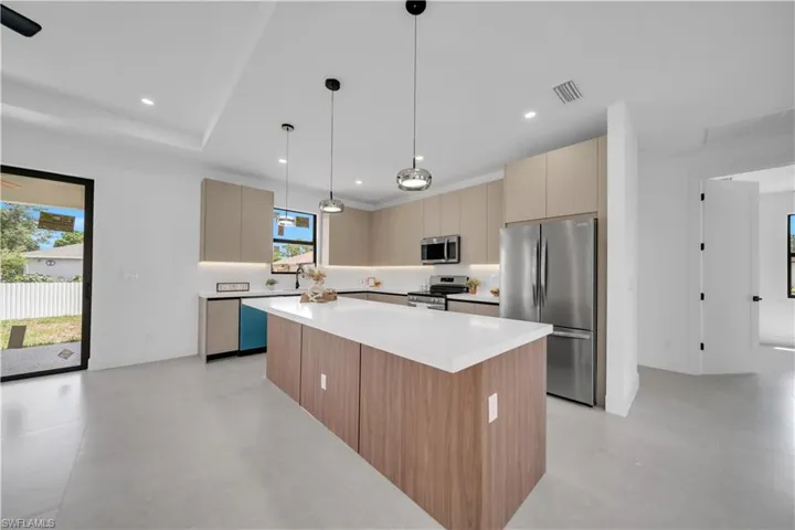 Contemporary kitchen featuring a spacious island with a white countertop and wood-finish paneling