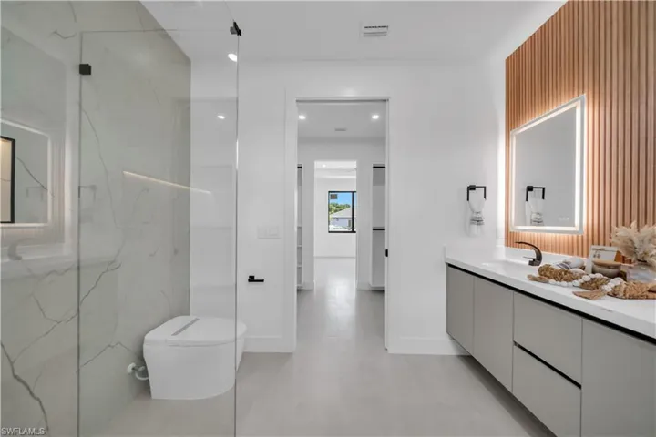 Contemporary bathroom featuring a floating vanity with a white countertop and dark hardware