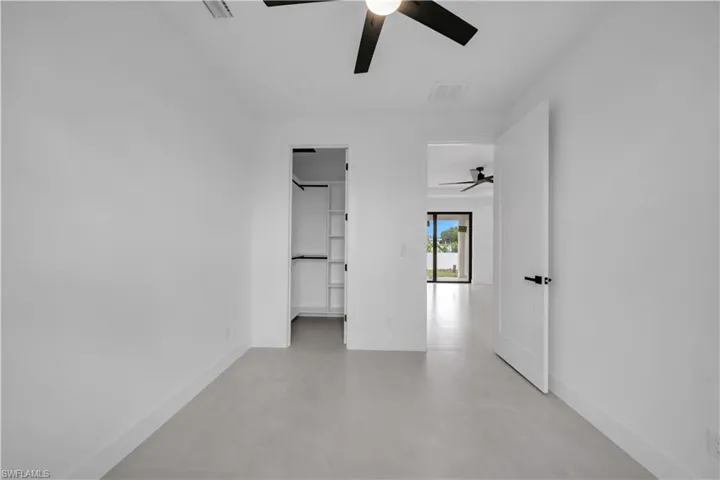 Room featuring light-toned flooring, white walls, and a ceiling fan