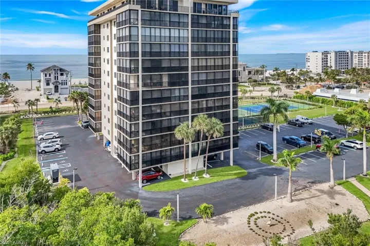 View of apartment building / complex with uncovered parking and a water view