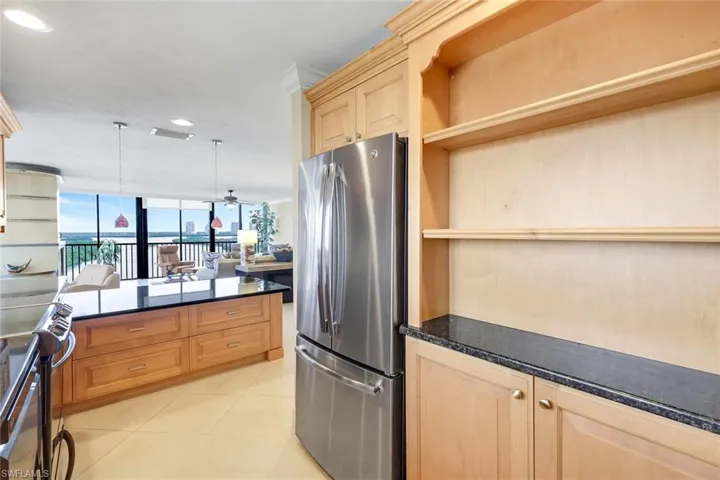 Kitchen with stainless steel appliances, recessed lighting, dark stone counters, light tile patterned floors, and a ceiling fan