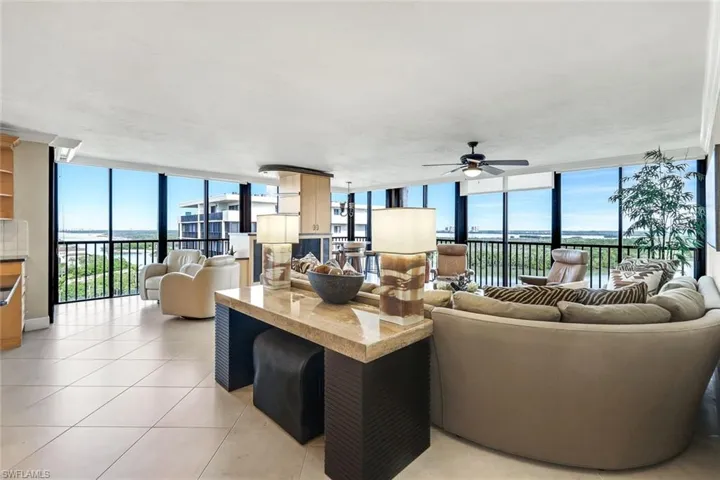 Living room featuring a wall of windows, a ceiling fan, light tile patterned floors, and plenty of natural light