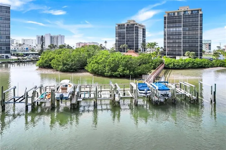 Dock area with boat lift, a water view, and a city view