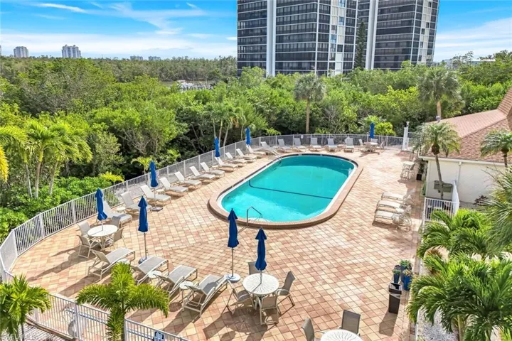 Community pool featuring a patio area and view of scattered trees
