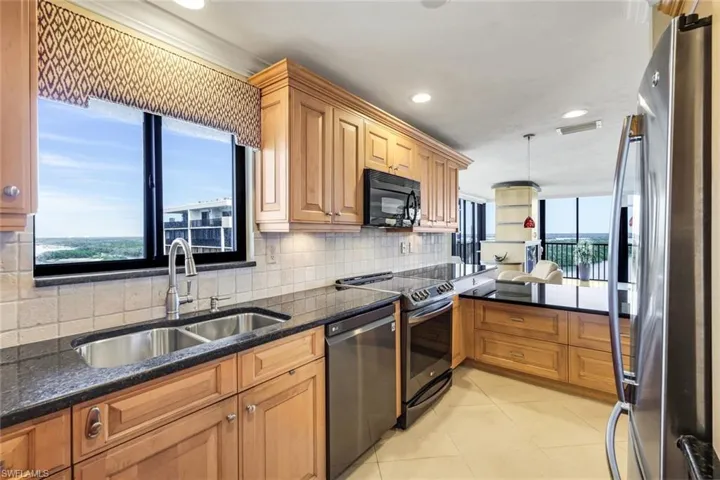 Kitchen featuring stainless steel appliances, dark stone counters, hanging light fixtures, recessed lighting, and backsplash