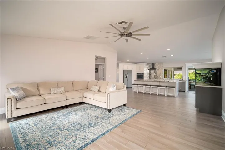 Living room featuring light hardwood / wood-style flooring, ceiling fan, and lofted ceiling