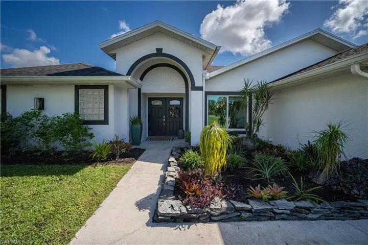 View of exterior entry with a lawn