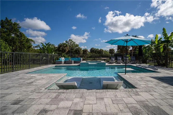 View of swimming pool with a patio area, an in ground hot tub, and outdoor lounge area