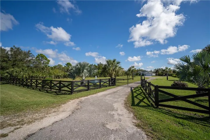 View of gate featuring a lawn and a rural view