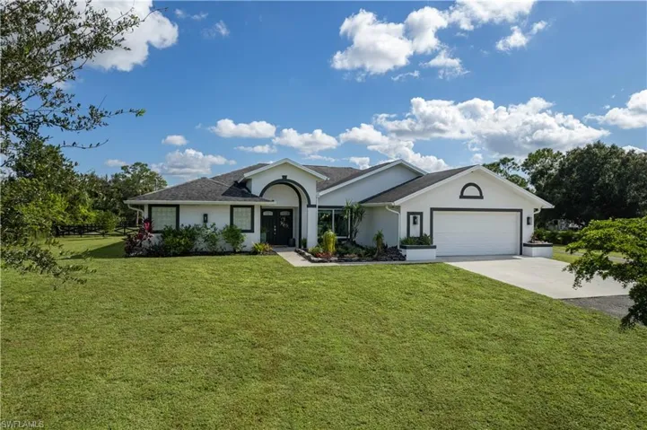 Ranch-style house with a front yard and a garage