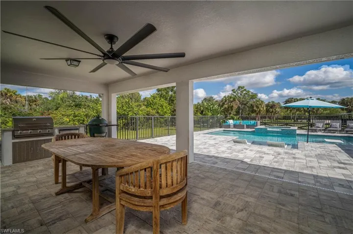 View of patio / terrace with a swimming pool with hot tub, ceiling fan, and a grill