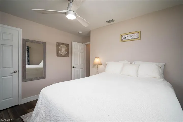 Bedroom with ceiling fan and dark wood-type flooring