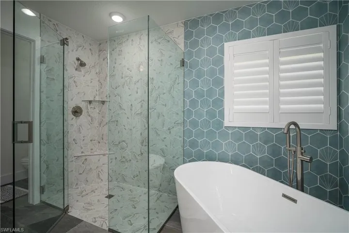 Bathroom featuring toilet, tile walls, plus walk in shower, and a textured ceiling