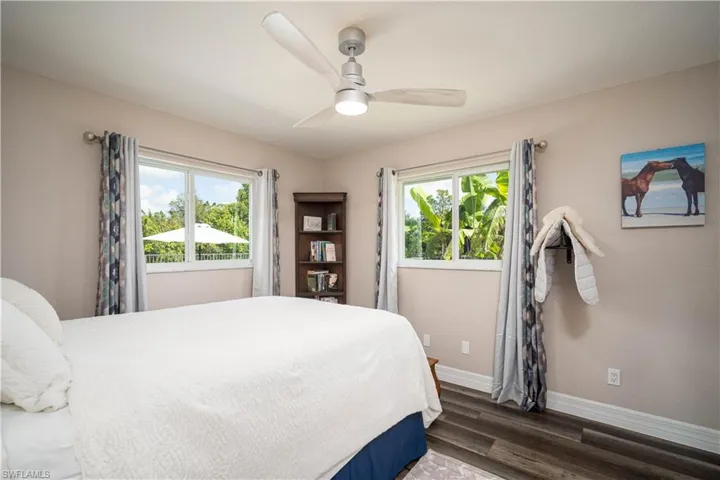 Bedroom featuring ceiling fan and dark wood-type flooring