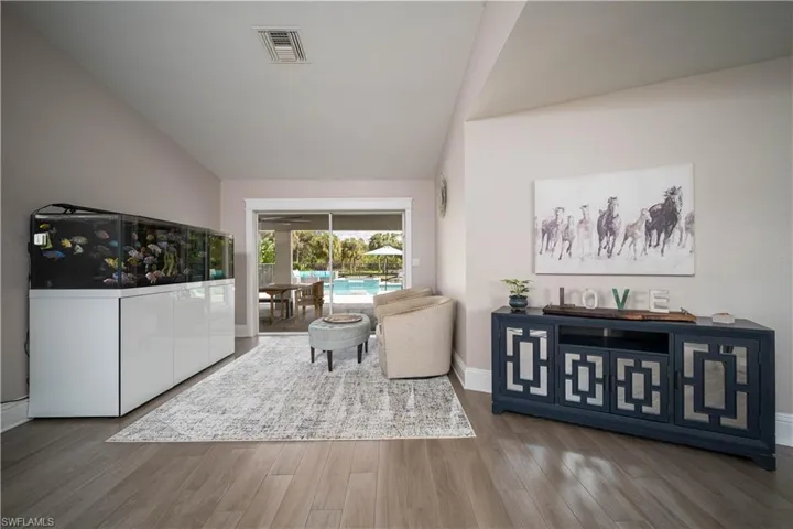 Sitting room featuring wood-type flooring, a pool, and lofted ceiling