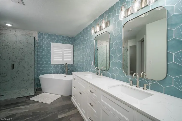 Bathroom featuring wood-type flooring, tile walls, plus walk in shower, and vanity