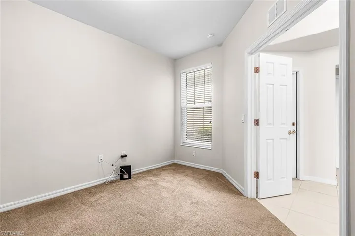 Empty room featuring light carpet and light tile patterned floors