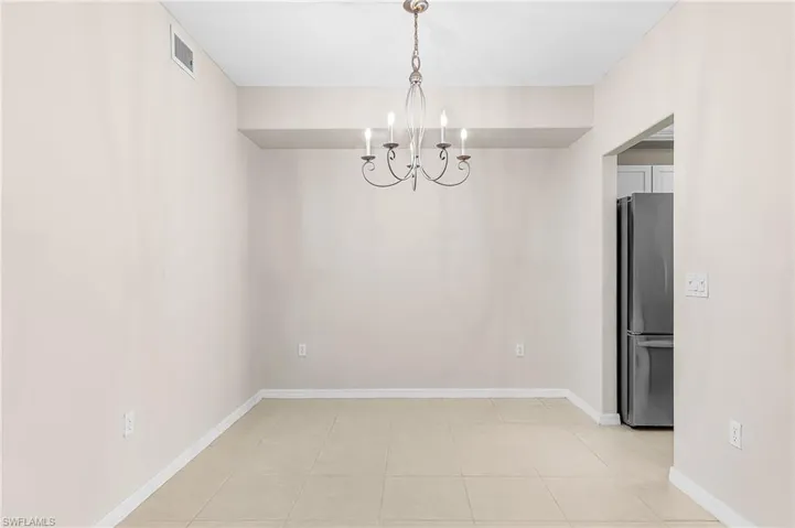 Unfurnished dining area featuring hanging lights and light tile patterned floors