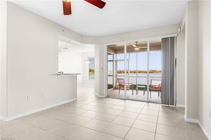 Spare room featuring ceiling fan, a water view, and light tile patterned flooring