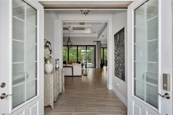 Corridor featuring a chandelier and a raised ceiling