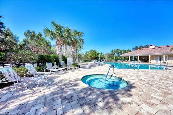 View of swimming pool with a patio and a hot tub