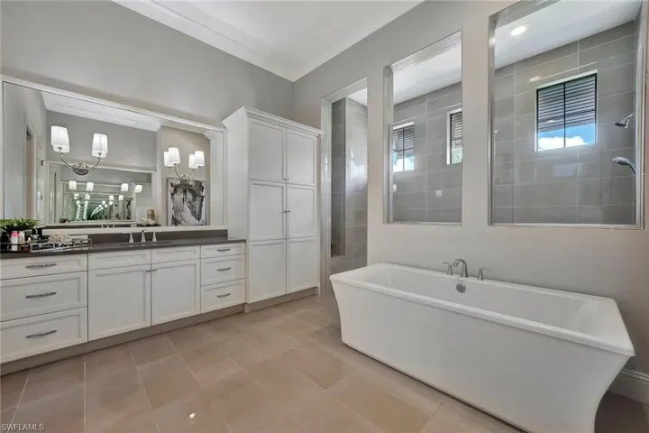 Master Bathroom with tile floors, ornamental molding, a bath, and vanity