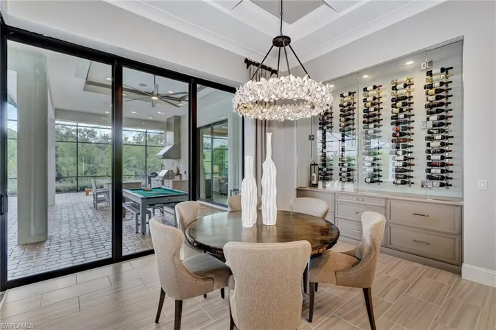 Dining space featuring a raised ceiling, an inviting chandelier, and light tile flooring