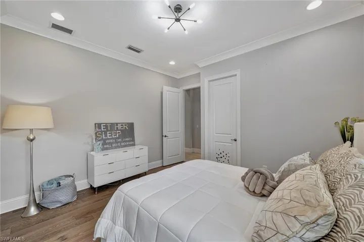 Bedroom with ornamental molding and hardwood / wood-style floors