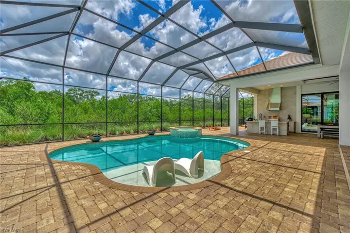 View of swimming pool featuring a patio, a lanai, and an in ground hot tub