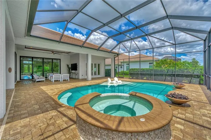 View of swimming pool featuring outdoor lounge area, glass enclosure, an in ground hot tub, ceiling fan, and a patio