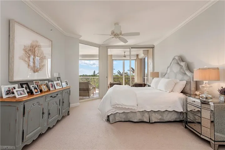 Carpeted bedroom with ceiling fan, crown molding, and access to outside