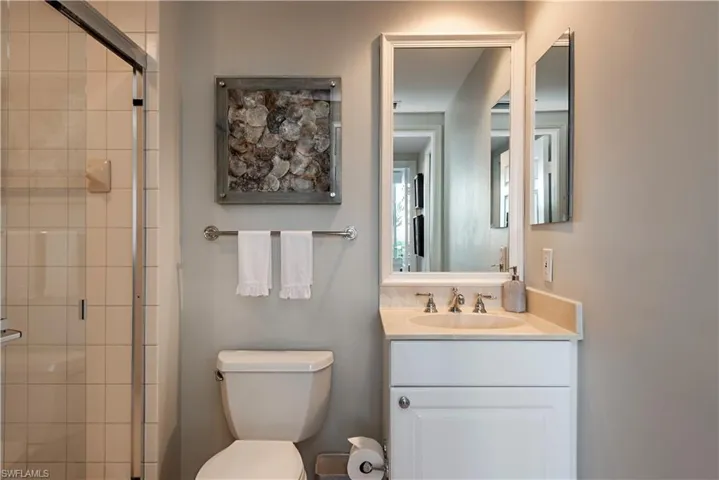 Bathroom with vanity, toilet, and a shower with shower door