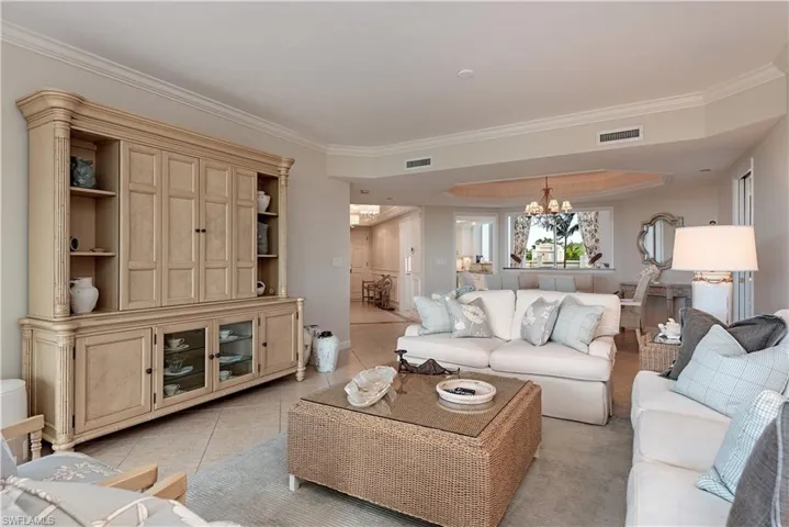 Tiled living room featuring a chandelier and crown molding