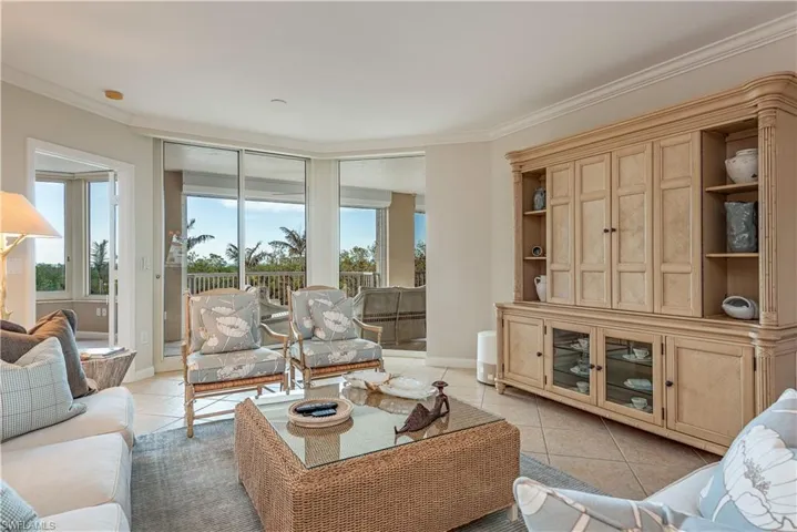 Living room featuring ornamental molding and light tile patterned flooring