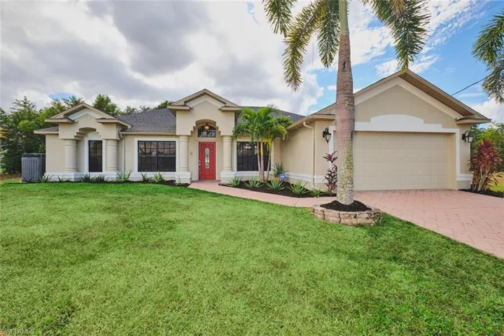 View of front of property with stucco siding, a front lawn, decorative driveway, and a garage