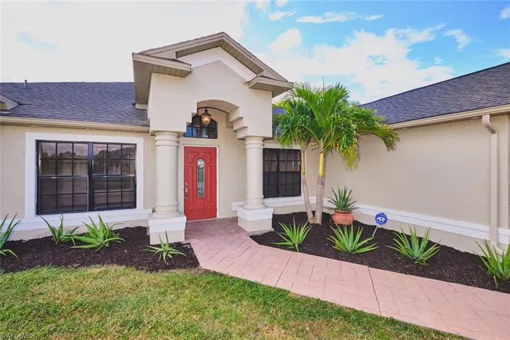 Property entrance with stucco siding and roof with shingles
