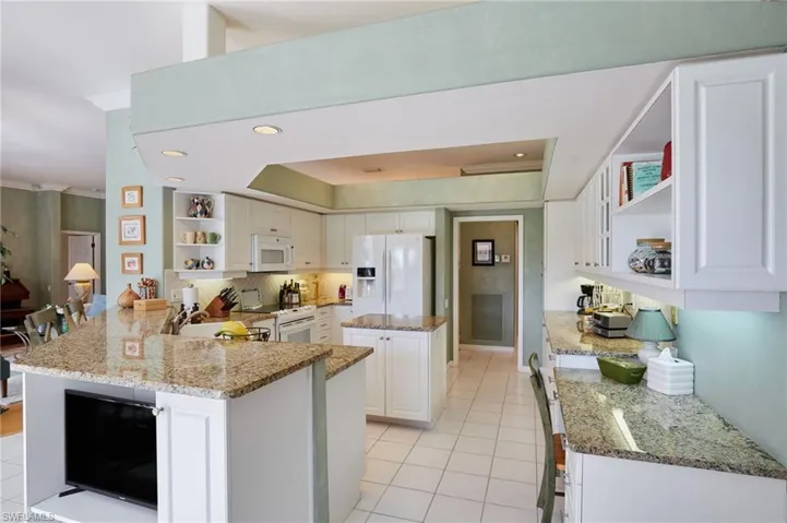 Kitchen area showing island, desk and open shelves