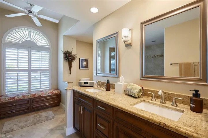 Bathroom featuring double vanity and sinks and storage bench