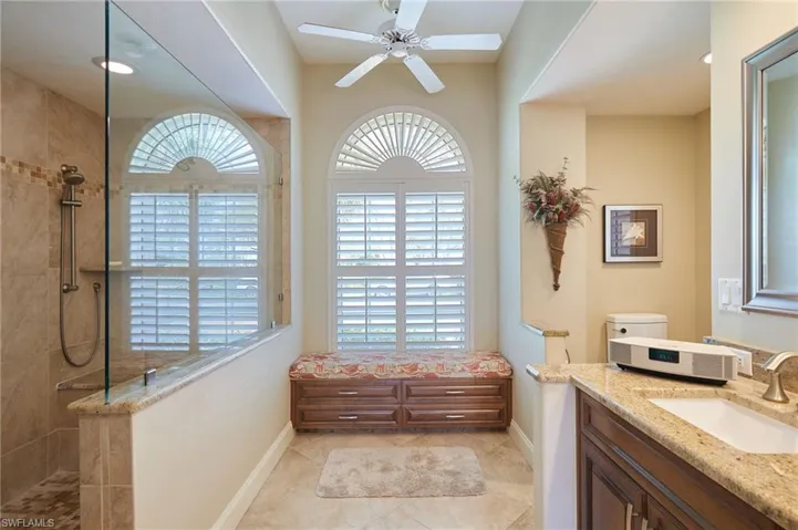 Full bath with ceiling fan, huge walk in shower, and double sink vanity