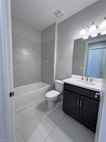 Full bathroom with vanity and light tile patterned floors