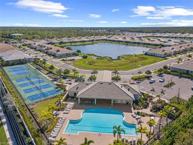 Aerial perspective of suburban area with a pool and a nearby body of water