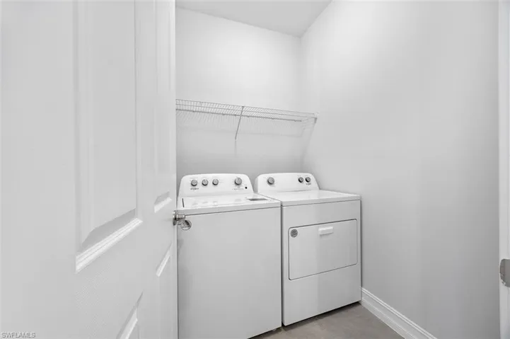 Laundry area featuring baseboards and washing machine and dryer