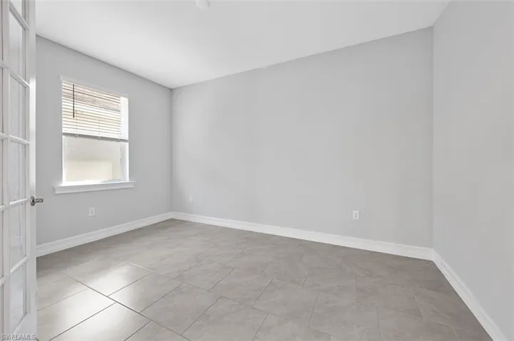 Unfurnished room with baseboards and light tile patterned floors