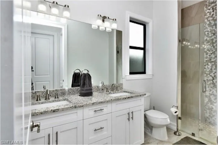 Full bath with a sink and a shower stall