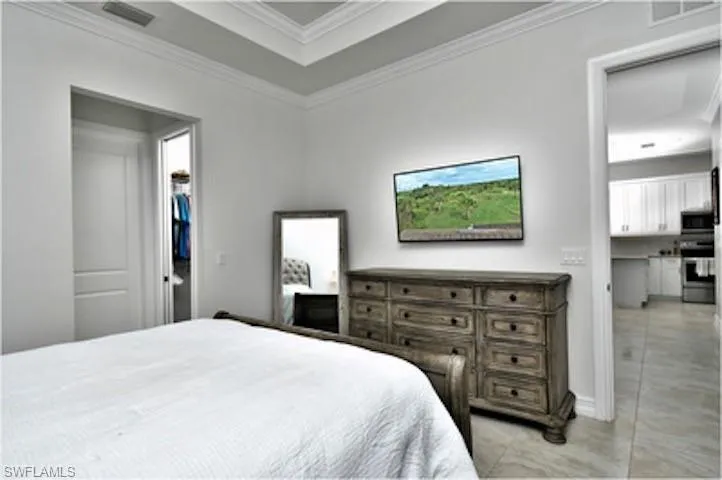 Bedroom featuring crown molding and light tile patterned floors